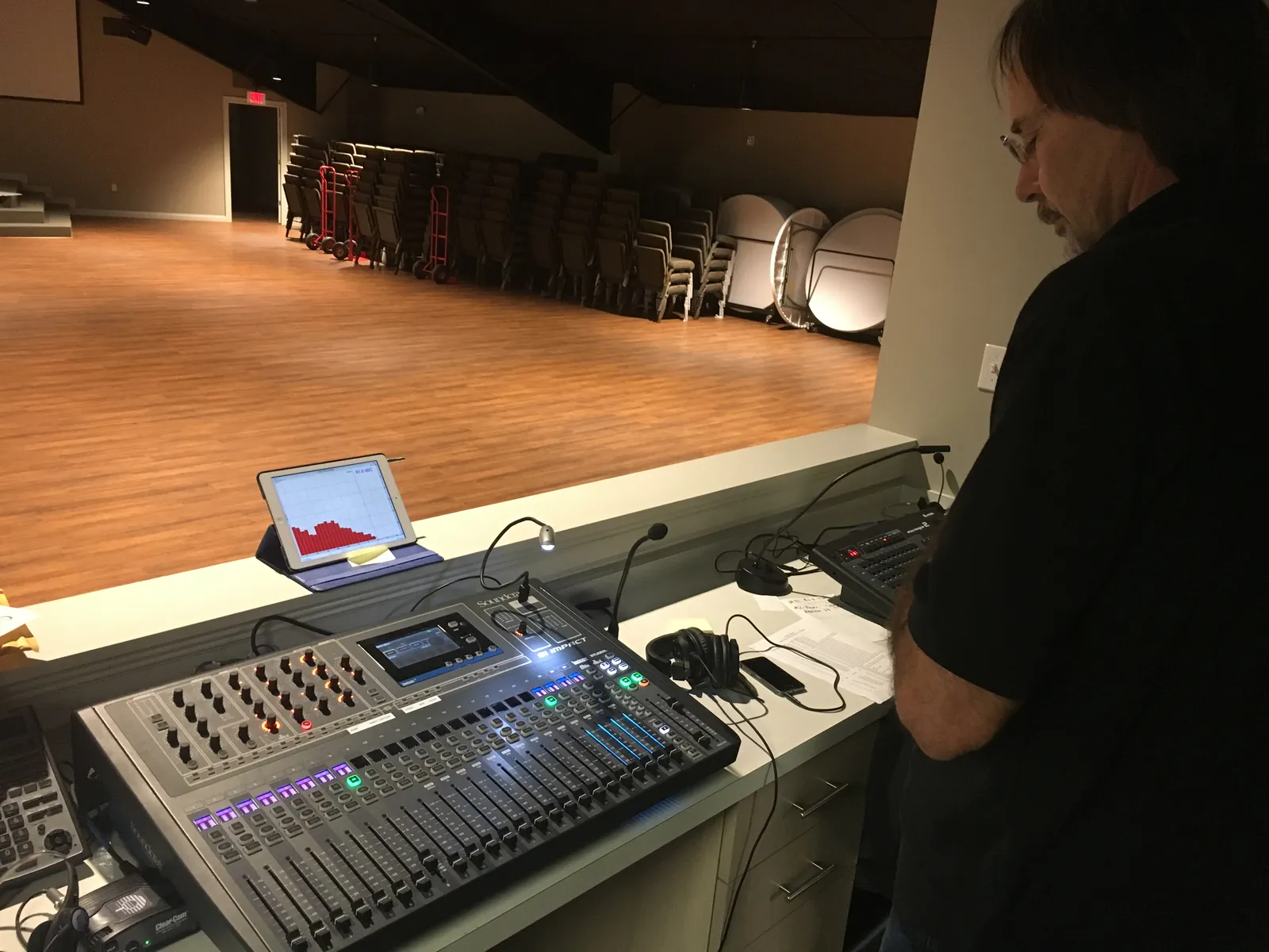 A service technician working on a rack of audio processing equipment